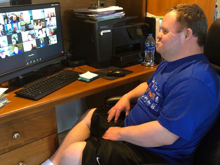 Josh Meyer sits at desk while attending LADD Live on his computer.