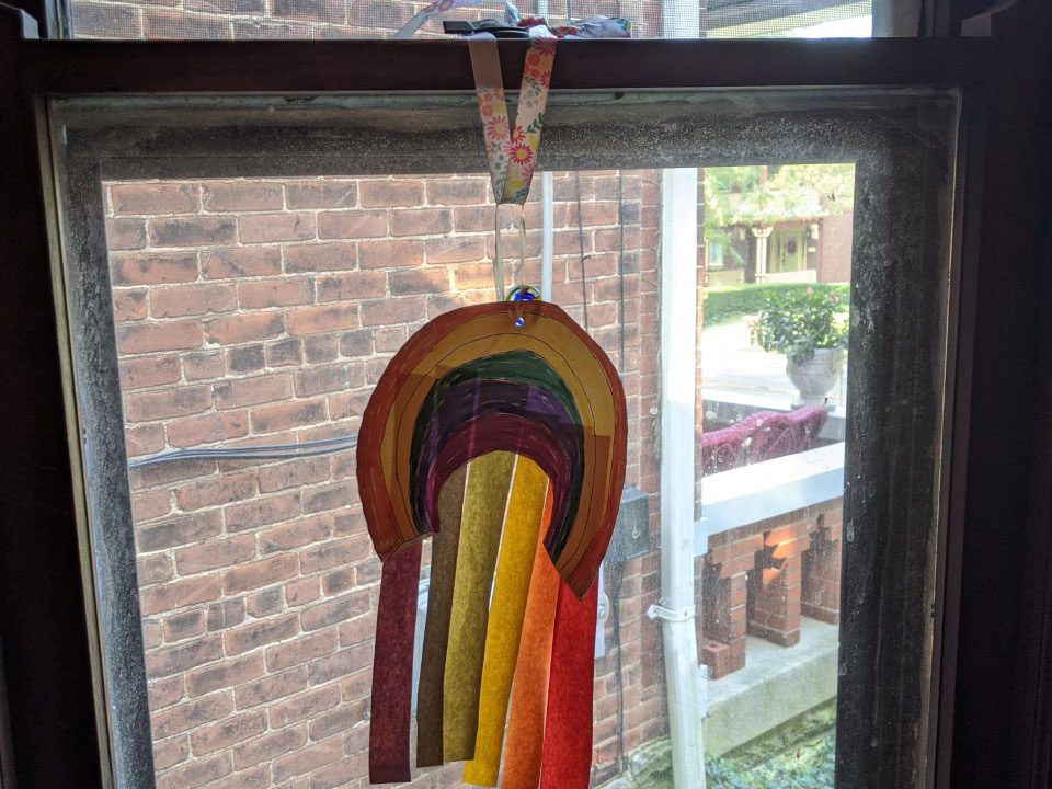 Rainbow artwork hanging on a window.